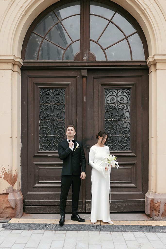 Bridal Couple standing in front of a big old door. Brautpaar steht vor einer alten historischen Tür. classy, chic, editorial bridal couple, civil wedding landau, Standesamtliche Hochzeit in Landau